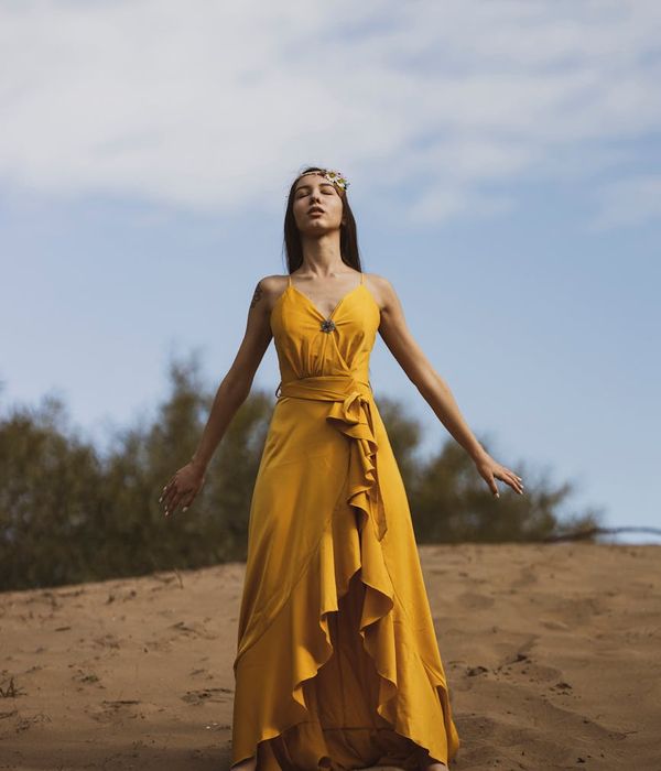 Woman in a graceful yoga pose with golden light accents.